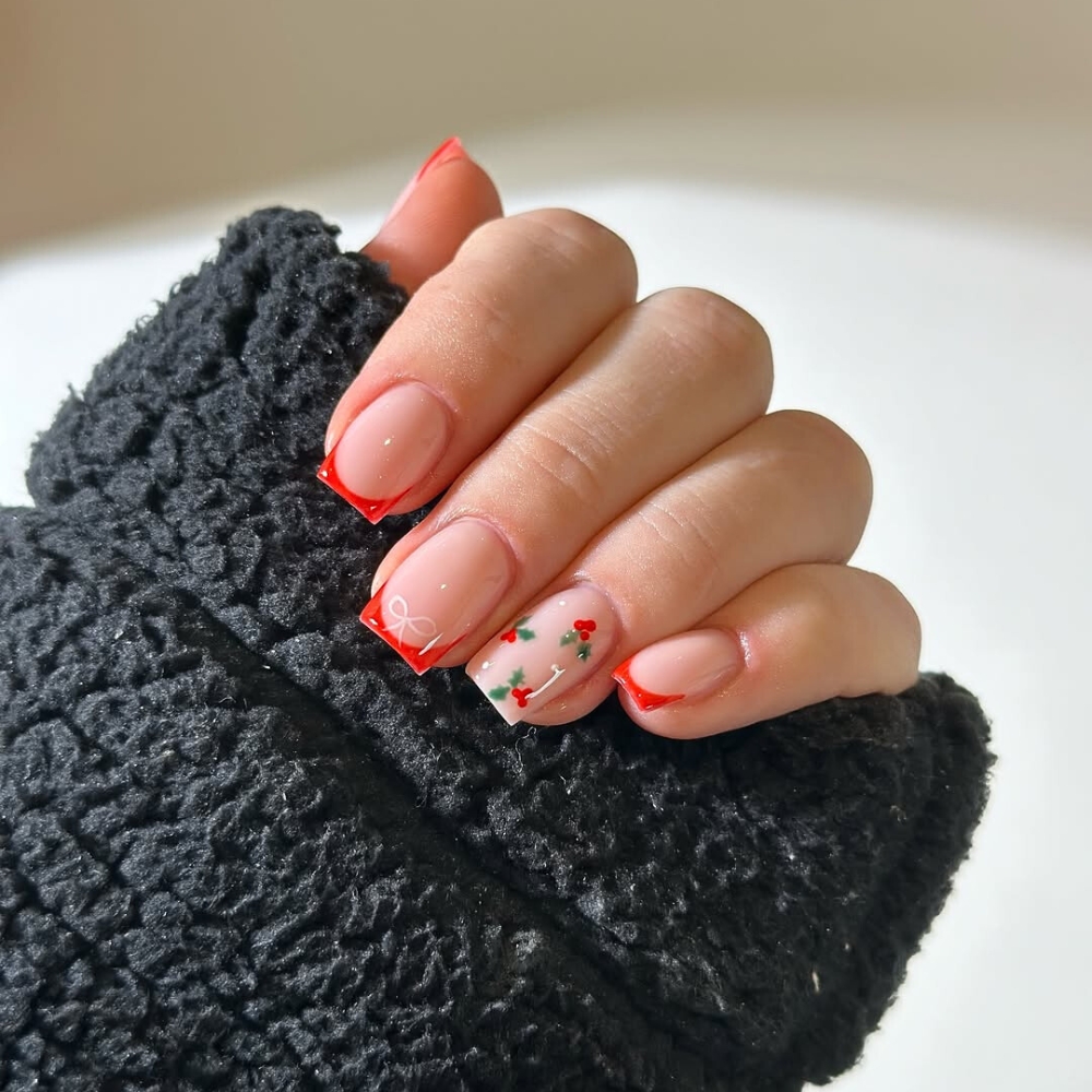 Nail kiểu Pháp mùa Giáng sinh: Mẫu nail Pháp với đầu móng được điểm xuyết bằng đường viền đỏ nổi bật mang đến cảm giác ấm áp của mùa Giáng Sinh. Bên cạnh đó, họa tiết quả cherry nhỏ nhắn cùng lá xanh tươi trên nền móng nude nhẹ nhàng càng làm tăng thêm vẻ nữ tính và ngọt ngào cho mọi cô gái