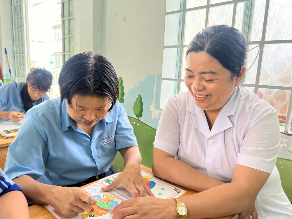 Cô Nguyễn Thị Hằng (bên phải) tận tình hướng dẫn học trò thực hiện bài tập tô màu