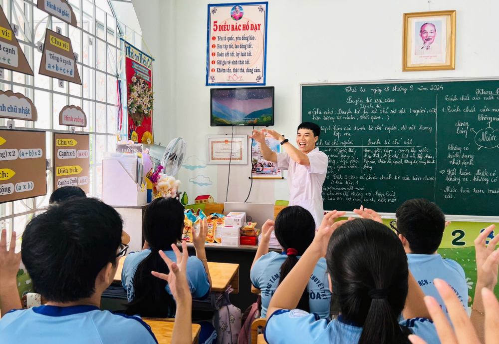 Thầy Nguyễn Văn Quang sử dụng ngôn ngữ ký hiệu trong giờ học để dạy các học sinh khiếm thính