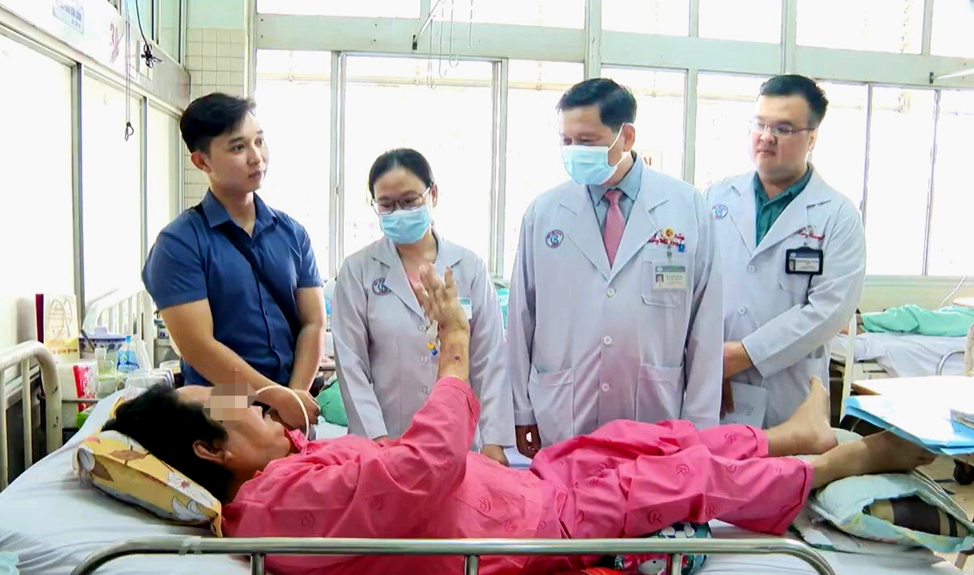 Bác sĩ Hoàng Bá Dũng (thứ hai từ phải qua) đang khám cho ông D.