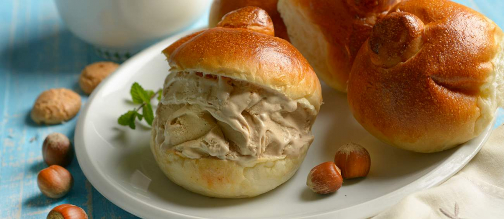  Brioche con gelato là một món tráng miệng Ý đặc trưng, đặc biệt phổ biến ở vùng Sicily. Món này gồm một chiếc bánh brioche mềm mịn, hơi ngọt, được cắt đôi và kẹp bên trong là gelato (kem Ý) với hương vị tùy chọn. Sự kết hợp giữa bánh brioche xốp và kem mát lạnh tạo nên trải nghiệm ẩm thực độc đáo. Đây là món ăn yêu thích vào mùa hè, thường dùng thay bữa sáng hoặc tráng miệng.