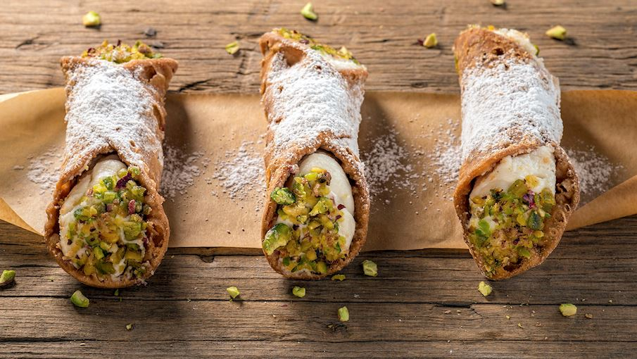 Cannoli là một món tráng miệng truyền thống nổi tiếng của vùng Sicily, Ý. Món này gồm phần vỏ bánh giòn rán vàng hình ống, được làm từ bột mì và rượu Marsala, bên trong là nhân kem ricotta mịn màng, thường pha thêm đường, socola, trái cây candied, hoặc hạt dẻ cười. Cannoli có nhiều kích cỡ, từ nhỏ gọn đến lớn, và thường được trang trí bằng đường bột hoặc topping như sô cô la vụn. Đây là món ngọt biểu tượng của ẩm thực Ý, rất được yêu thích trên toàn thế giới.