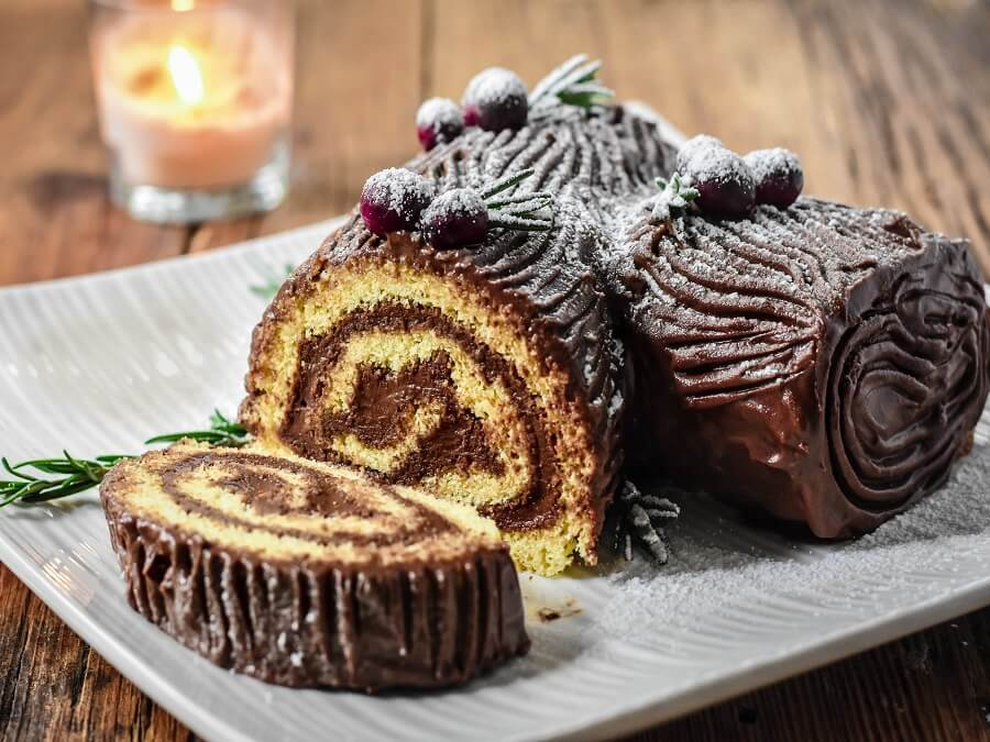 Bánh khúc cây (Yule Log Cake) là món tráng miệng truyền thống trong dịp Giáng Sinh, lấy cảm hứng từ hình ảnh khúc gỗ đốt trong đêm lễ hội. Bánh được làm từ cốt bánh cuộn mềm mịn, nhân kem bơ hoặc chocolate, bên ngoài phủ kem và trang trí như vân gỗ. Thường thêm các chi tiết như nấm kem, bột đường tạo hiệu ứng tuyết. Đây là món bánh vừa ngon miệng vừa mang ý nghĩa may mắn và ấm áp.