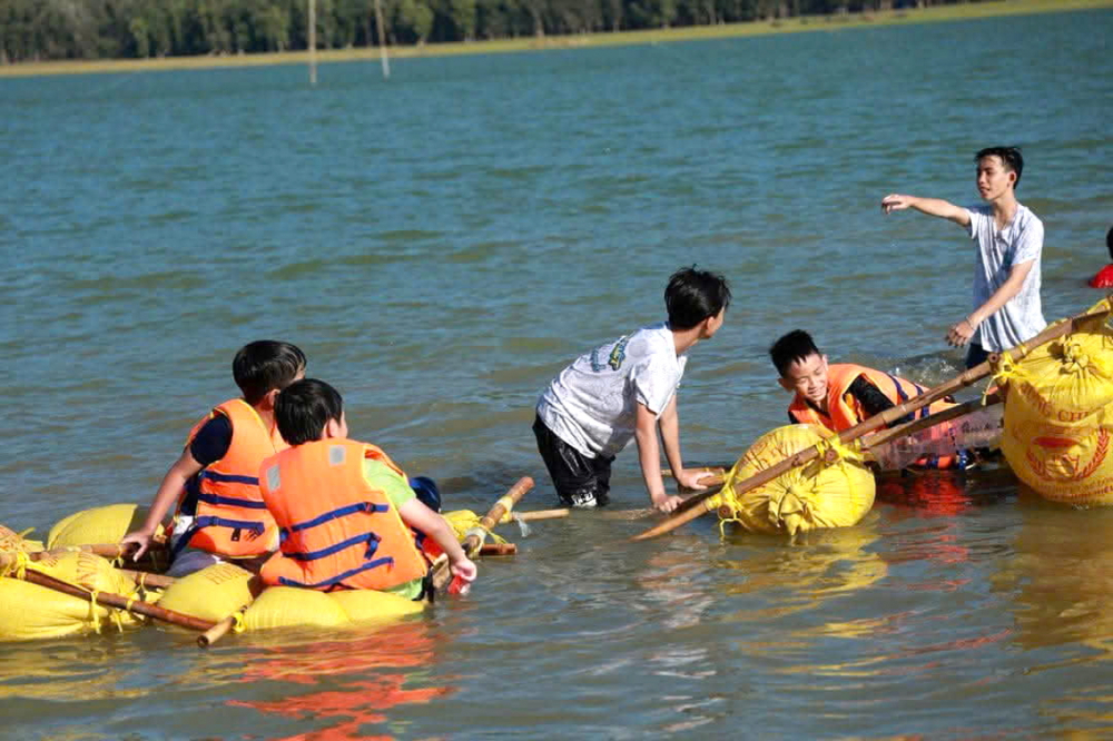 Dạy con các kỹ năng sống cũng là một bước quan trọng để trẻ sớm tự lập. Trong ảnh: Các em học sinh cấp II làm bè vượt sông bằng tre và túi ni lông - ẢNH: TR.THẮNG