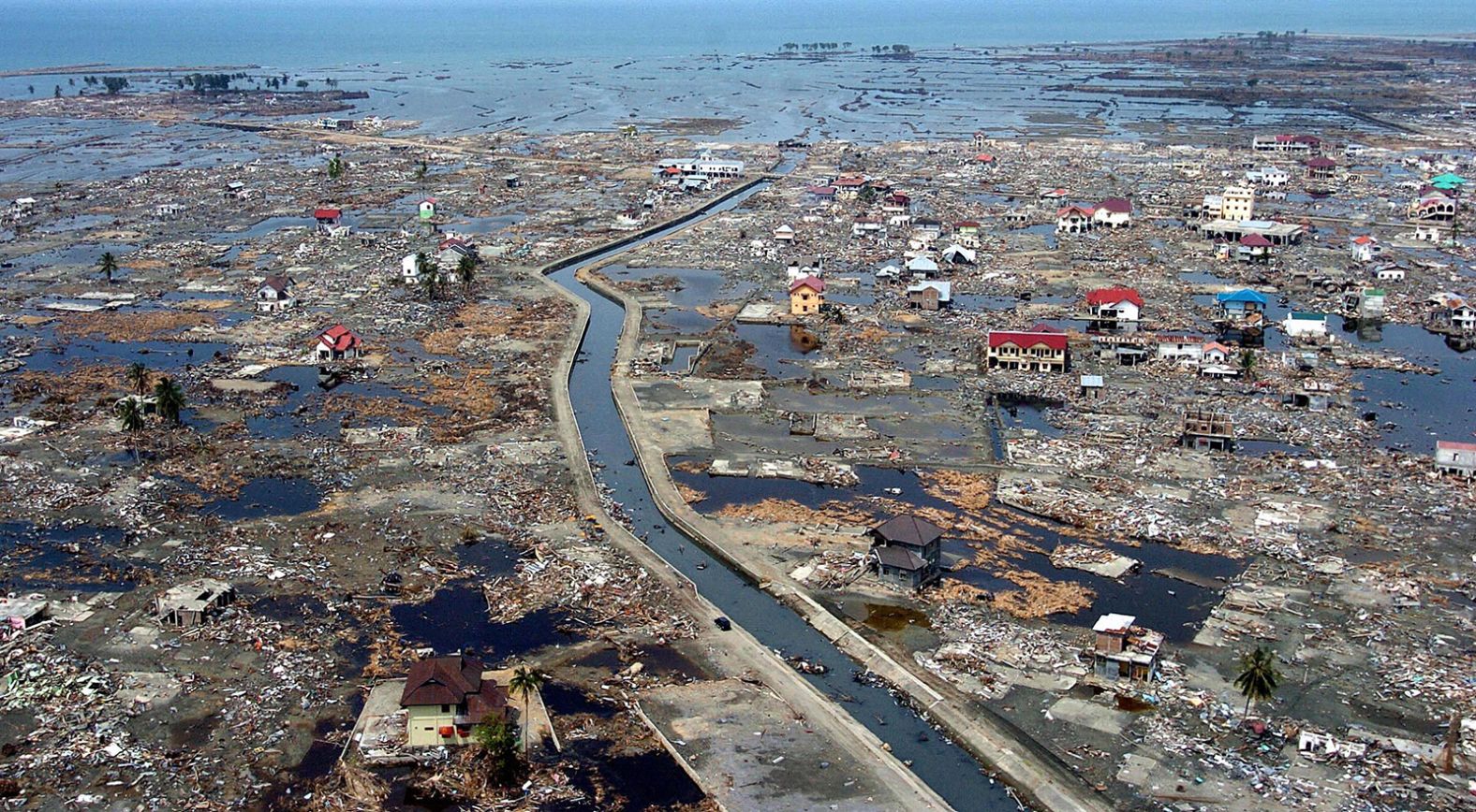 Cảnh tàn phá có thể nhìn thấy ở vùng ven biển Banda Aceh, Indonesia, gần hai tuần sau trận sóng thần. “Tôi hy vọng chúng tôi sẽ không bao giờ phải trải qua điều đó nữa”, Nilawati, một bà nội trợ người Indonesia 60 tuổi đã mất con trai và mẹ trong thảm kịch và đang tham dự lễ tưởng niệm hôm thứ năm, cho biết.  “Tôi đã học được sự tàn phá của việc mất đi một đứa con, một nỗi đau mà tôi không thể diễn tả bằng lời. Cảm giác như nó mới xảy ra ngày hôm qua. Bất cứ khi nào tôi nhớ lại, cảm giác như toàn bộ máu dồn ra khỏi cơ thể tôi.”Choo Youn-Kong/AFP/Hình ảnh Getty