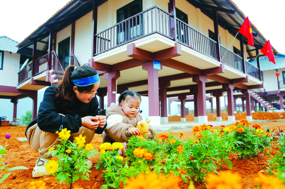 Mẹ con chị Nguyễn Thị Sành trong khuôn viên nhà mới ở khu tái định cư thôn Làng Nủ, xã Phúc Khánh, huyện Bảo Yên, tỉnh Lào Cai ẢNH: H.N.