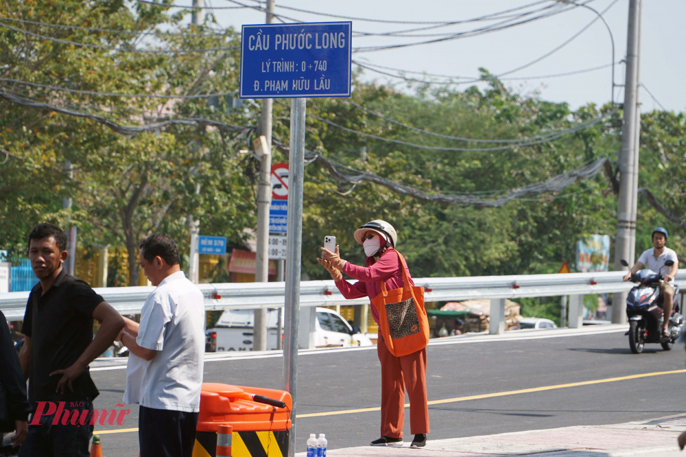 Người dân ra chụp hình những chiếc xe đầu tiên lưu thông qua cầu sau lễ thông xe.