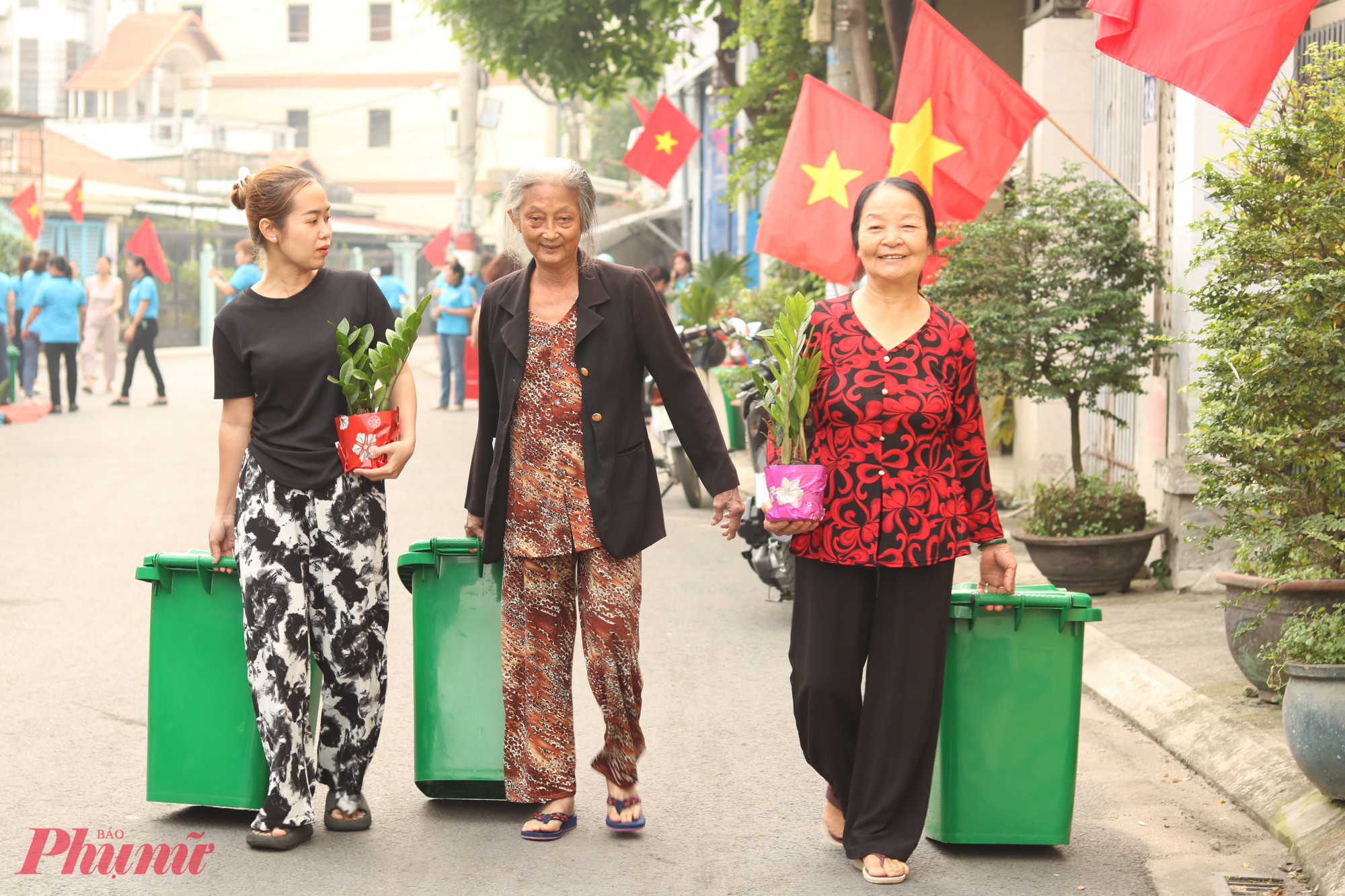 Đại diện các hộ dân trên đường TA04 phấn khởi với món quà của hội là những thùng chứa rác, những chậu cây xanh. 