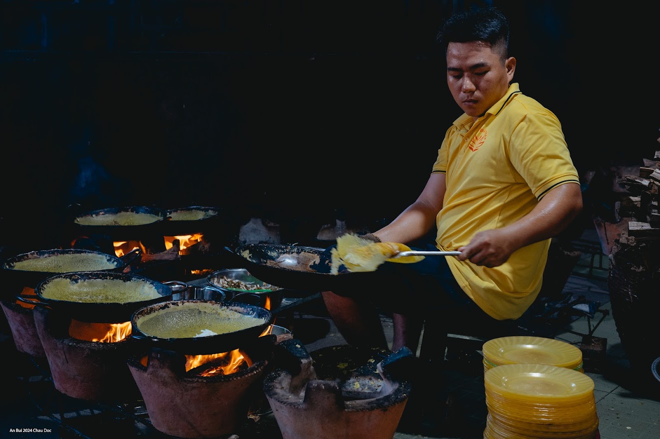 Để đến Chùa bánh xèo, từ trung tâm TPHCM, xe chúng tôi di chuyển về thành phố Châu Đốc, sau đó, đi tiếp theo QL91C và QL91. Nếu sợ lạc đường, bạn có thể tham khảo Google Maps hay hỏi người dân địa phương. Nếu đi xe khách, khi đến Châu Đốc, bạn có thể gọi xe ôm đến chùa.  Thiền viện Đông Lai nằm dưới chân núi Cậu và được xây dựng theo kiến trúc phái thiền Trúc Lâm. Theo lời anh Vinh, hướng dẫn viên (kiêm người nhà), thiền viện được xây dựng từ năm 1999, do Hòa thượng Thích Thiện Chí làm trụ trì. Ban đầu, sư thầy trong chùa đổ bánh xèo để chiêu đãi phật tử viếng chùa, người nghèo và dân lao động quanh đó. Sau, nhiều người nghe tiếng tìm đến nên hiện mọi khách viếng chùa, nếu muốn đều có thể thưởng thức bánh xèo miễn phí.  Khu vực thưởng thức bánh xèo thuộc dãy nhà sau của chùa, nơi có khoảng 20 chiếc bàn inox, một chiếc tủ đựng rau, những chồng đĩa nhựa (và một người quản lý tủ - người phụ xếp rau, xếp đĩa). Khách sau khi vãn cảnh chùa, muốn thưởng thức bánh xèo, có thể bước sang khu vực này, lấy đĩa, đứng xếp hàng gần giàn bếp, đầu bếp sẽ cho bánh chín nóng hổi vào đĩa. Sau khi có bánh, mỗi người tự tìm chỗ ngồi, tự phục vụ rau, nước mắm, nước uống.  Khi tôi đến, có khoảng 2 giàn bếp đất nung xếp thành hình bán nguyệt (khoảng 30 khuôn) do ba người đàn ông đứng bếp đang đỏ lửa. Bánh xèo tại đây là bánh xèo kiểu miền Nam, được đổ trong chảo gang.  Bột bánh xèo được làm từ bột gạo pha nước dừa. Nhân bánh tùy thời điểm sẽ được thêm một vài đặc sản (như bông điên điển mùa nước nổi), còn thường sẽ có đậu xanh nguyên hạt, tàu hũ, giá đỗ, có thêm nấm mèo, củ sắn xắt sợi… và rau sống ăn kèm. Theo người tình nguyện khu vực tủ rau, tất cả nguyên liệu của món ăn đều do người dân và phật tử mang đến.