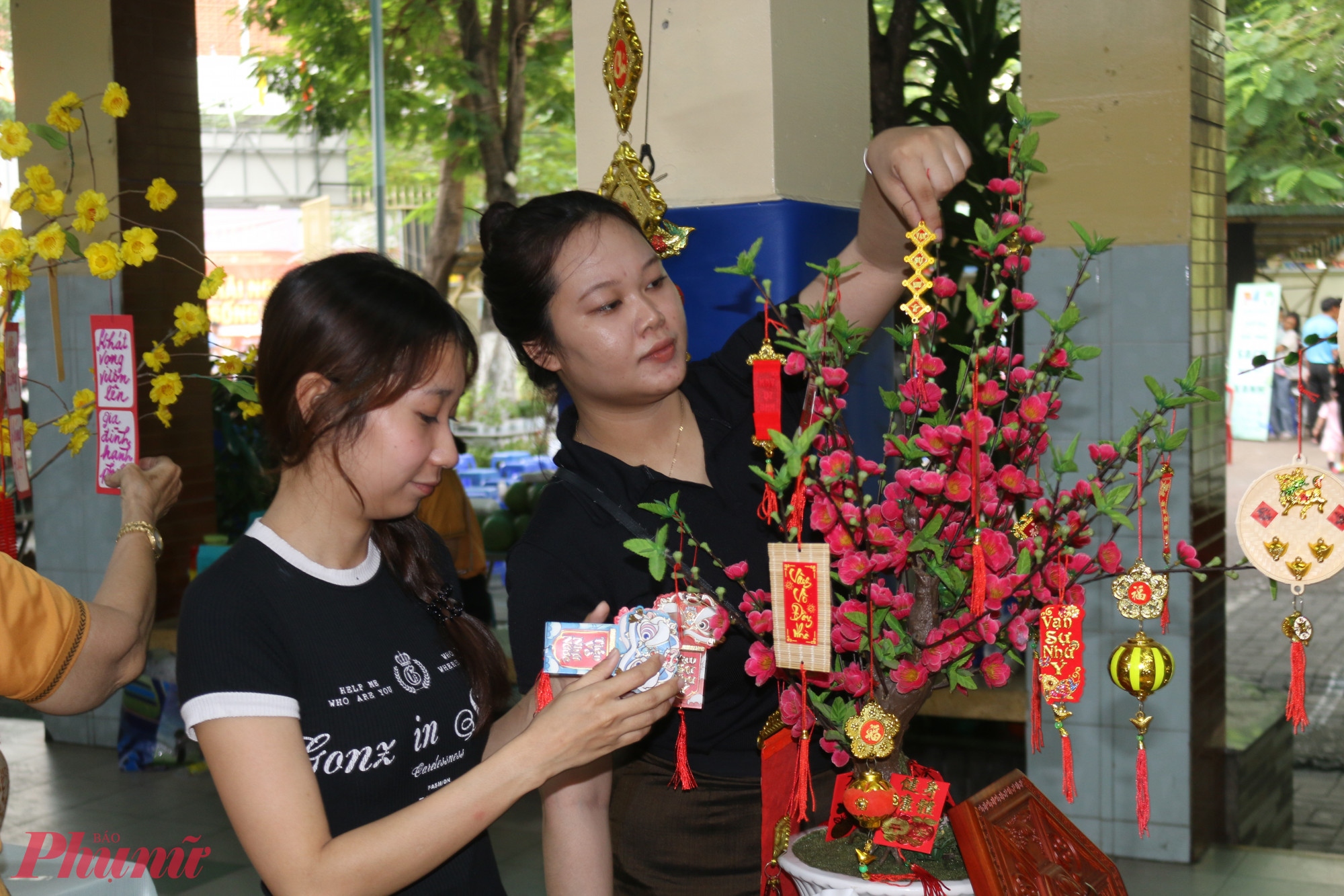 Ban Philaketh Phuangpaserth, sinh viên năm 4 ngành Y đa khoa tại Trường Đại học Nguyễn Tất Thành (thứ hai từ trái sang), chăm chú trang trí hoa. Bạn chia sẻ rằng từ khi được các mẹ người Việt nhận nuôi, mình đã có cơ hội tìm hiểu thêm về những nét truyền thống của người Việt. Thông qua hoạt động hôm nay, bạn cảm nhận rõ hơn không khí gia đình và sự gắn kết, điều khiến bạn thêm trân trọng những giá trị văn hóa và tình cảm mà mọi người dành cho nhau.