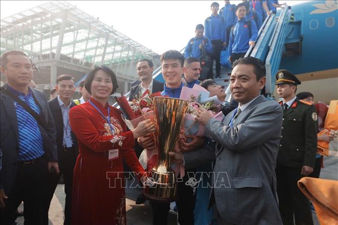 Thứ trưởng Bộ Văn hóa, Thể thao và Du lịch Hoàng Đạo Cương và Phó Cục trưởng Cục TDTT Lê Thị Hoàng Yến đón đội tuyển tại chân cầu thang máy bay với chiếc cúp vô địch ASEAN Cup 2024. Ảnh: Minh Quyết/TTXVN