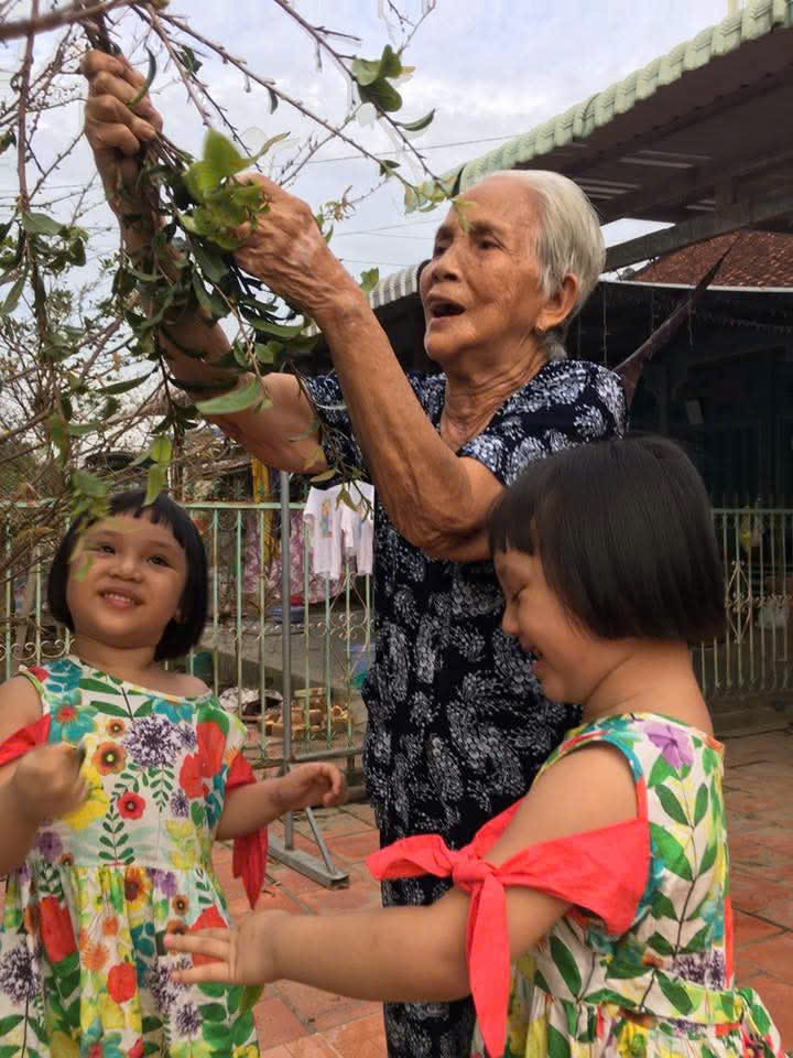 Niềm vui lặt lá mai của ba bà cháu. Ảnh T.D