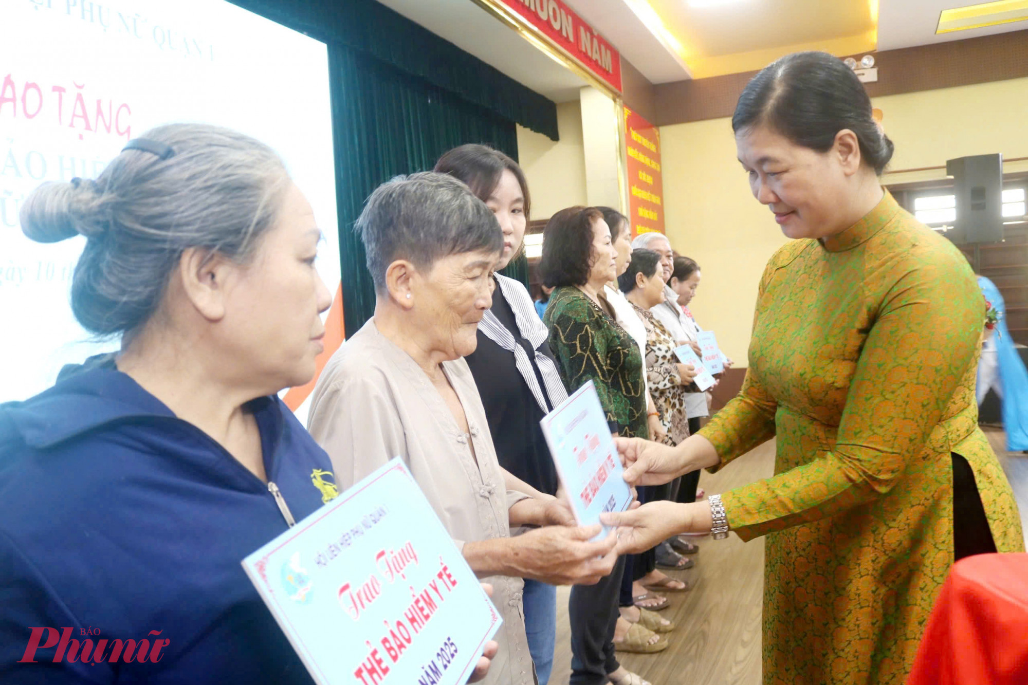 Bà Hoàng Thị Tố Nga – Phó bí thư thường trực Quận uỷ Quận 1 – trao bảng tượng trưng thẻ bảo hiểm y tế cho các chị. 