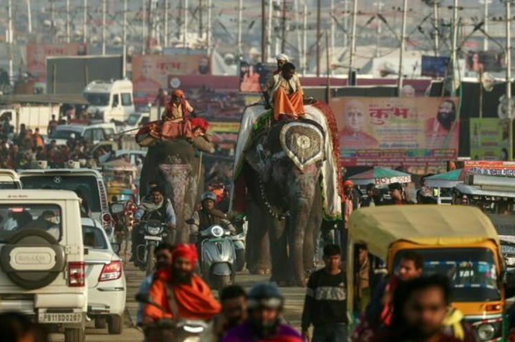 Các nhà sư Hindu mang theo những lá cờ lớn của giáo phái mình bắt đầu diễu hành về phía bờ sông vào tối Chủ Nhật. Những chiếc máy kéo biến thành cỗ xe ngựa chở những bức tượng thần Hindu có kích thước bằng người thật chạy phía sau, cùng với đàn voi, trong khi những người hành hương hân hoan theo nhịp trống và tiếng còi xe inh ỏi. Lễ hội này bắt nguồn từ thần thoại Hindu, là trận chiến giữa các vị thần và ác quỷ để giành quyền kiểm soát chiếc bình chứa mật hoa bất tử. Các nhà tổ chức gọi đây là lễ hội Kumbh Mela vĩ đại hoặc “Maha”.