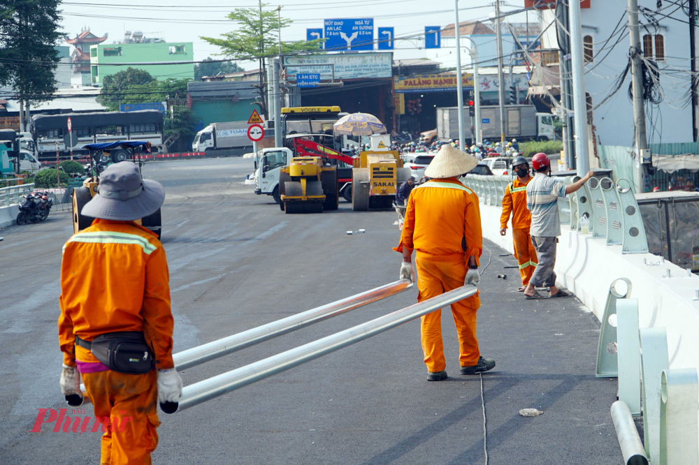 Công nhân đang lắp đặt những đoạn lan can cầu còn lại.