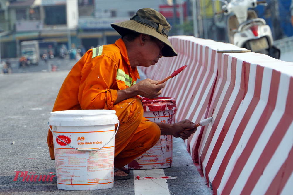 Công nhân tiến hành sơn màu lên dải phân cách cố định ở những vị trí đã được bố trí.