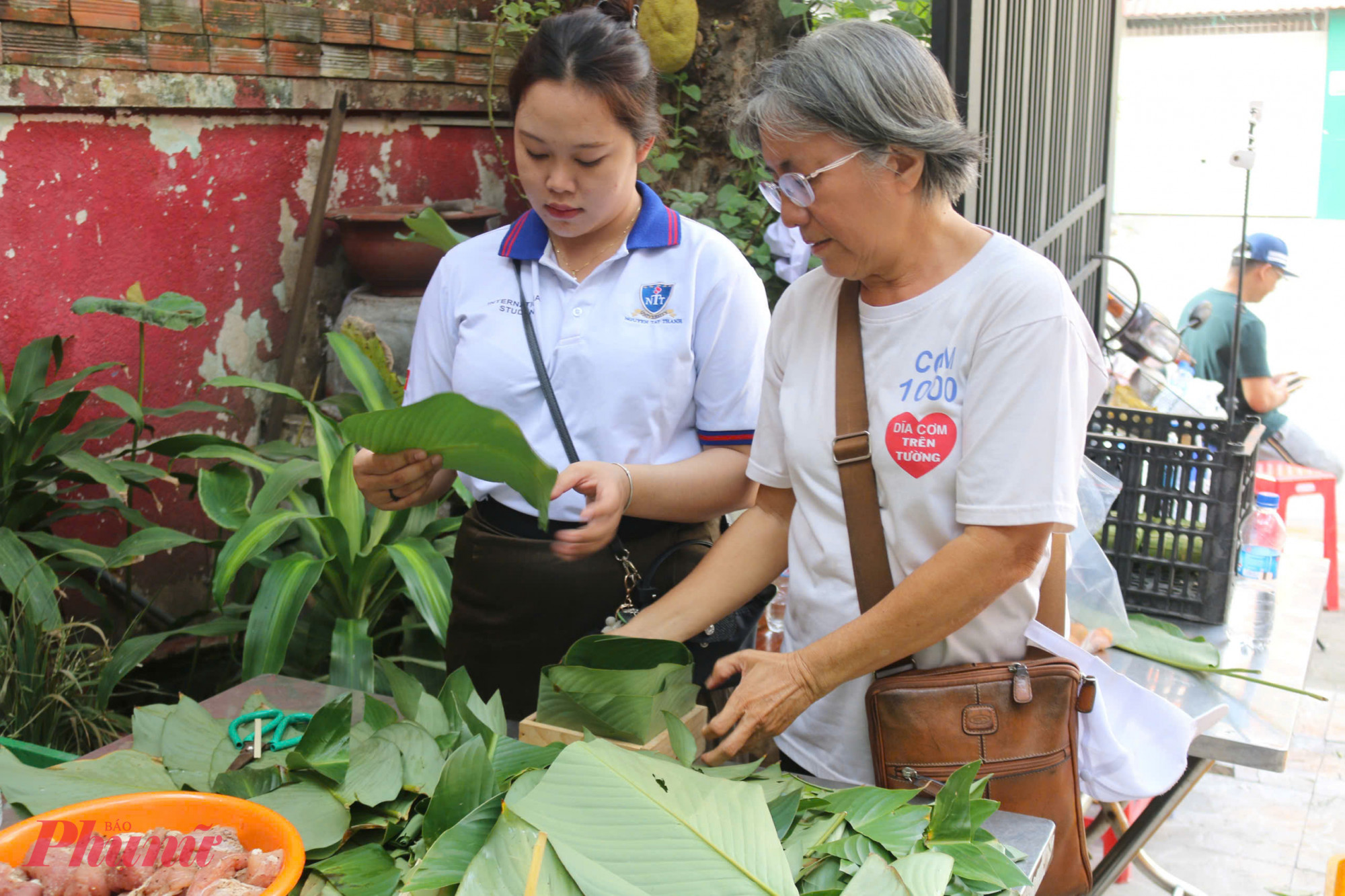  Bà Lê Thị Ngọc Thủy hướng dẫn các bạn sinh viên Lào gói bánh chưng