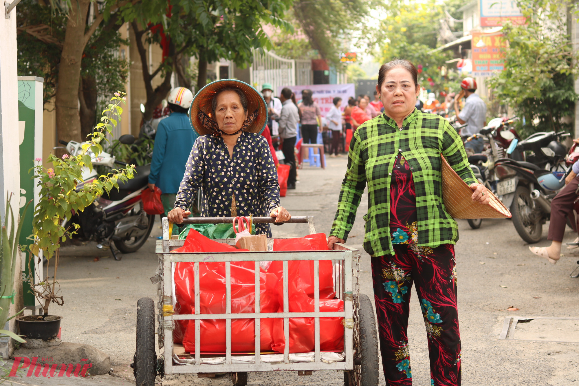 Bà Lưu Thị Cải (bìa trái) và bà Đặng Thị Lợi thay mặt chị em trong khu trọ đi lãnh quà tết vào ngày 19/1.