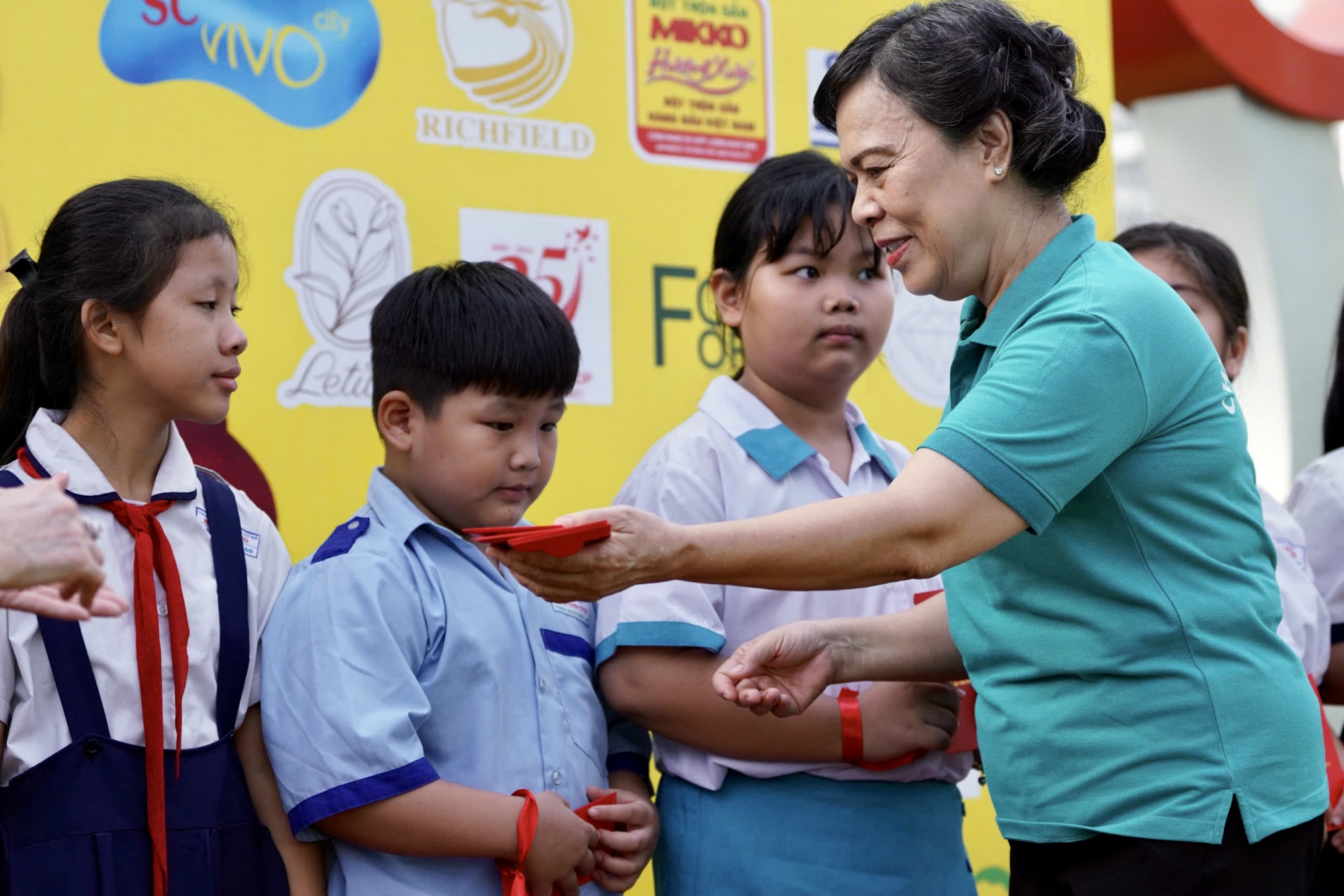 Bà Mai Thị Hạnh, phu nhân nguyên Chủ tịch nước Trương Tấn Sang - tặng lì xì cho trẻ em tham dự chương trình - Ảnh: Vũ