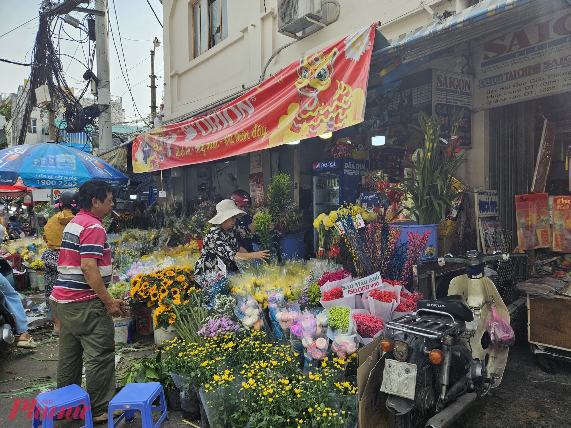 Tại chợ Thị Nghè (quận Bình Thạnh), người dân mua sắm tấp nập từ sáng tới chiều. Các quầy trái cây, hoa và đồ trang trí tết được luôn đông đúc. Trừ xoài, sung, mãng cầu tròn và dừa… thì giá các loại hầu như không tăng so với ngày thường. 