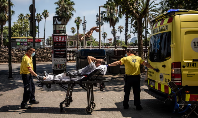 Nhân viên y tế giúp một bệnh nhân vào xe cứu thương trong đợt nắng nóng ở Barcelona, ​​Tây Ban Nha, vào tháng 7. Ảnh: Bloomberg/Getty Images