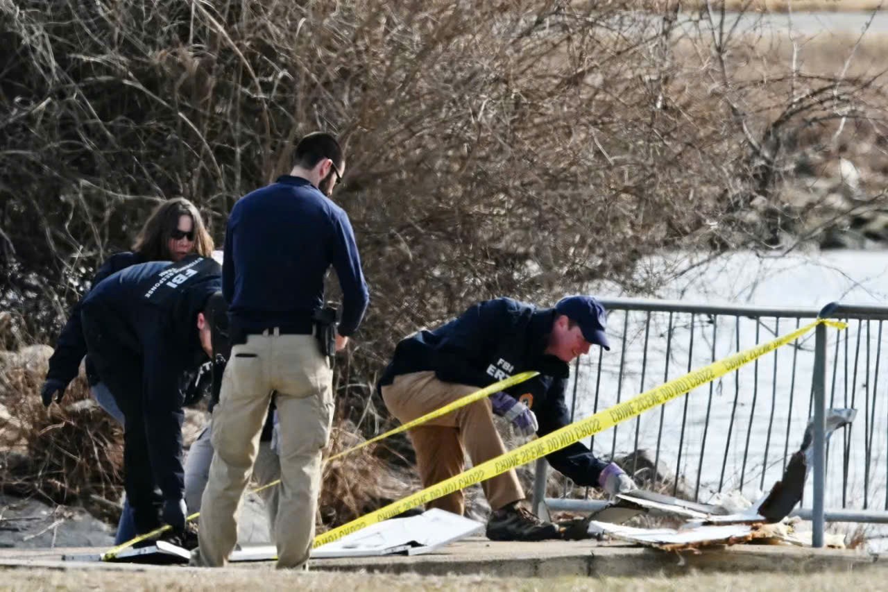 Các nhà điều tra thu thập các mảnh vỡ máy bay dọc theo sông Potomac - Ảnh: AFP