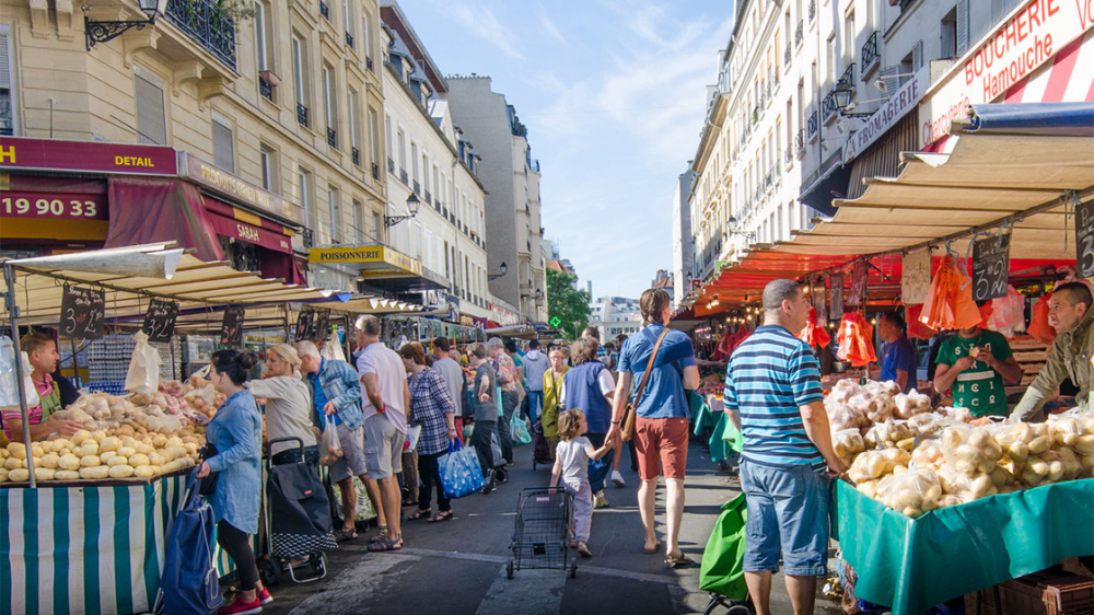 Marché des Enfants Rouges, khu chợ lâu đời nhất Paris, trở nên sống động vào mùa xuân với không khí ấm áp và sắc màu rực rỡ. Các quầy hàng rau củ, trái cây tươi theo mùa như dâu tây, măng tây và atiso thu hút đông đảo người mua sắm. Những gian hàng ẩm thực quốc tế – từ ẩm thực Pháp, Ý đến Maroc và Nhật Bản – trở nên nhộn nhịp hơn khi mọi người thưởng thức món ăn ngoài trời. Hương thơm từ hoa tươi, gia vị và bánh ngọt hòa quyện trong không gian chợ cổ kính.