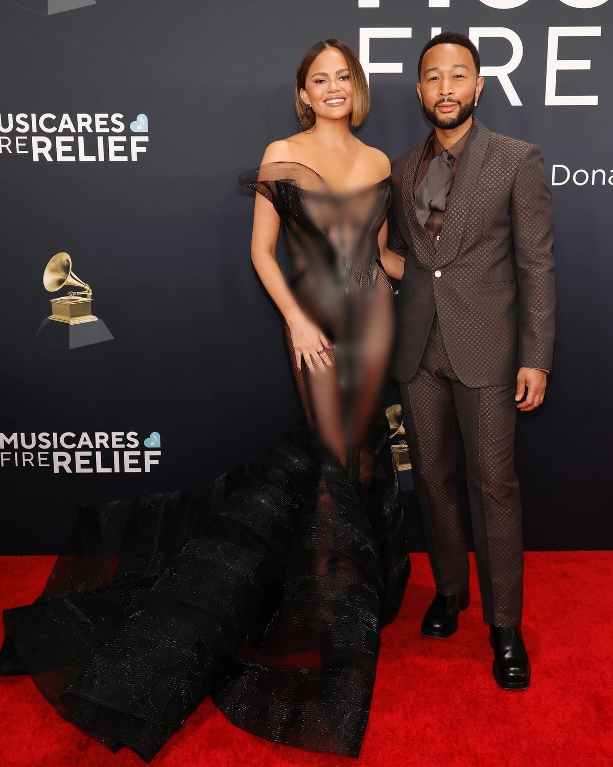 Ca sĩ John Legend lịch lãm trong bộ suit màu nâu chocolate đậm, tháp tùng vợ - diễn viên Chrissy Teigen. Cô diện bộ cánh xuyên thấu, thiết kế cầu kỳ khoe dáng.