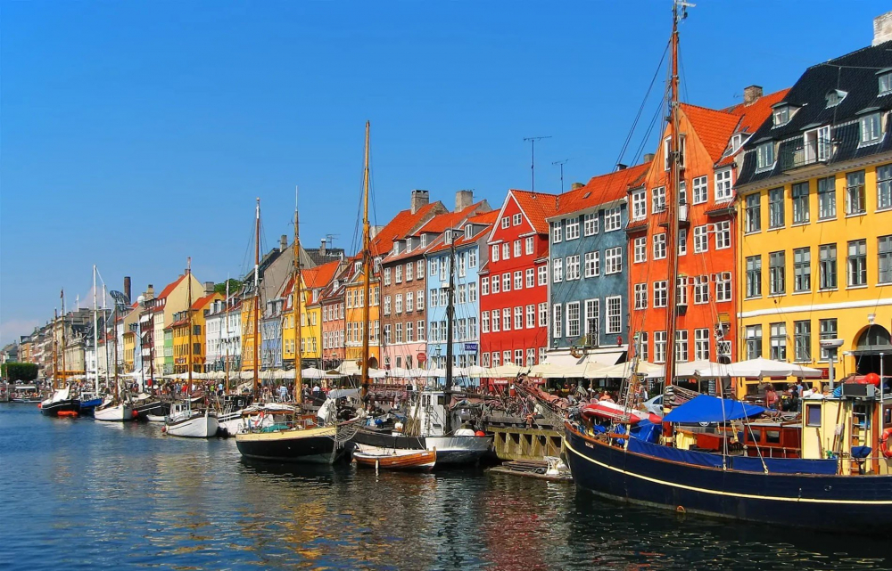 Copenhagen là một điểm đến du lịch hấp dẫn nhờ sự kết hợp giữa lịch sử, văn hóa và phong cách sống hiện đại. Thành phố này nổi tiếng với những công trình kiến trúc cổ kính như Cung điện Amalienborg, Lâu đài Rosenborg và biểu tượng Nàng tiên cá nhỏ (The Little Mermaid). Với hệ thống kênh đào thơ mộng và những con phố dành cho xe đạp, Copenhagen mang đến không gian yên bình và thân thiện với môi trường. Ẩm thực nơi đây cũng đặc sắc với những nhà hàng đạt sao Michelin và món smørrebrød truyền thống. Không chỉ vậy, khu vui chơi Tivoli Gardens cổ kính và những quán cà phê ấm cúng tạo nên một nhịp sống thư thái nhưng đầy sức hút, khiến du khách khó lòng rời xa.