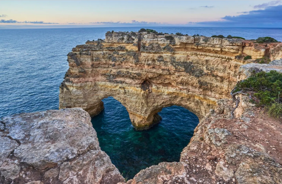 Vách đá Praia da Marinha, Bồ Đào Nha. Dọc theo bờ biển Algarve, có những tảng đá nhô lên trên mặt nước tạo thành hình trái tim nên là điểm đến không bỏ lỡ của tình nhân. Với những vách đá tuyệt đẹp và làn nước tĩnh lặng để bơi, Praia da Marinha là một trong những nơi được yêu thích khi đến Bồ Đào Nha. Ảnh trên: Bình minh trên vách đá Praia da Marinha dọc theo bờ biển Algarve nổi tiếng ở miền Nam Bồ Đào Nha - Ảnh: GETTY