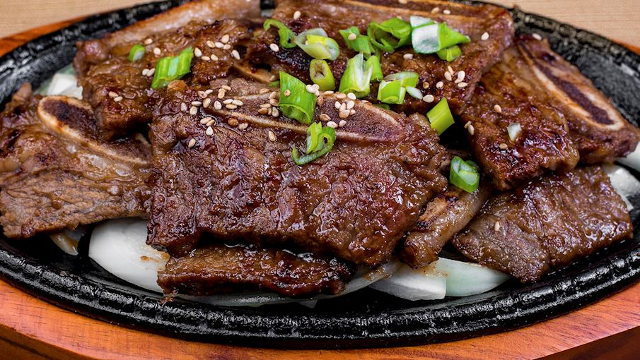 2/ Galbi (hay Kalbi) là tên gọi chung cho nhiều món sườn bò nướng phổ biến trong ẩm thực Hàn Quốc. Sườn thường được ướp trong nước sốt ngọt gồm nước tương, đường, rượu gạo, dầu mè và tỏi. Dù tên gọi có nghĩa là sườn, nhưng thịt gà hoặc thịt lợn cũng có thể được sử dụng thay thế.Món ăn này có nguồn gốc từ Hàn Quốc vào thế kỷ 18, khi việc giết mổ bò bị cấm. Tuy nhiên, do nhu cầu dinh dưỡng của các công nhân xây dựng pháo đài Hwaseong, vua Jeongjo đã cho phép mở một lò mổ duy nhất trên toàn quốc để cung cấp thịt bò cho họ.