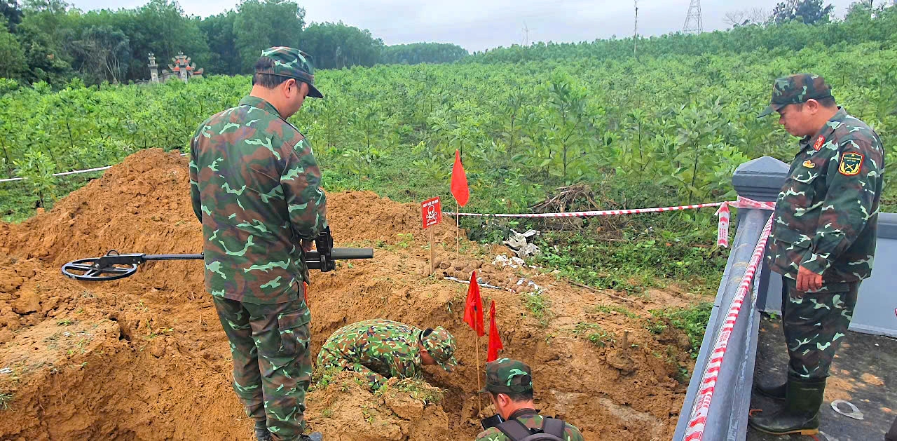 Lực lượng công binh khoanh vùng khu vực hầm đạn tại vị trí của một hộ dân đang triển khai xây dựng lăng mộ người thân