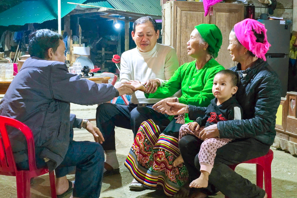 Thầy mo Lữ Trọng Bằng (áo trắng) tái hiện nghi lễ buộc chỉ cổ tay trong lễ đón tiếng sấm - ẢNH: PHAN NGỌC