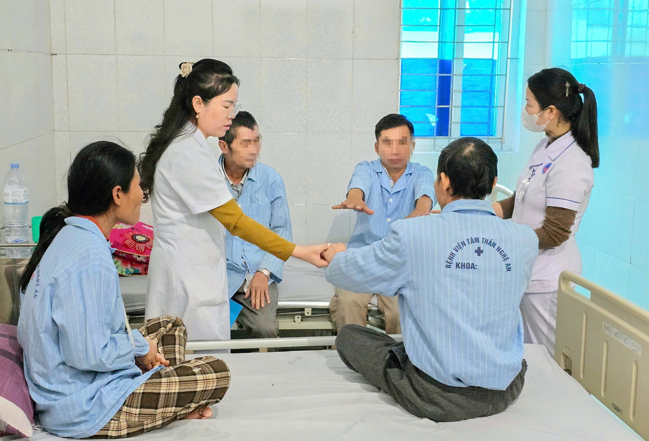 Bác sĩ Phạm Thị Anh (đứng, bìa trái) thăm hỏi, trò chuyện với các bệnh nhân