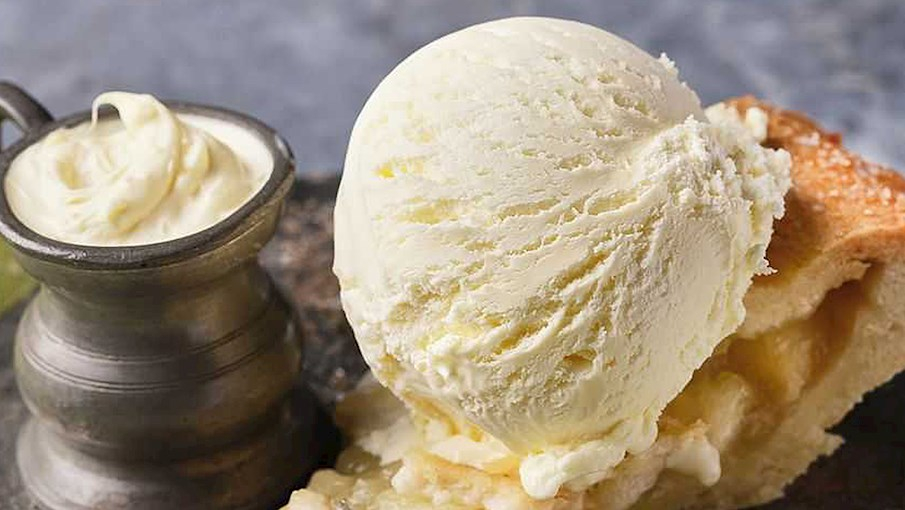 Clotted cream ice cream là món kem tráng miệng đặc biệt có nguồn gốc từ Anh, làm từ clotted cream – một loại kem sữa béo ngậy. Nhờ hàm lượng chất béo cao, kem có kết cấu mịn màng, vị béo đậm đà và thơm ngon hơn so với kem thông thường. Đây là món ăn được yêu thích ở vùng Devon và Cornwall, thường được dùng kèm với bánh ngọt hoặc trái cây. Hương vị của nó mang đến cảm giác sang trọng và tinh tế, phù hợp cho những ai thích kem sữa béo. Một muỗng nhỏ cũng đủ để cảm nhận sự mềm mại và ngọt ngào tan chảy trên đầu lưỡi.