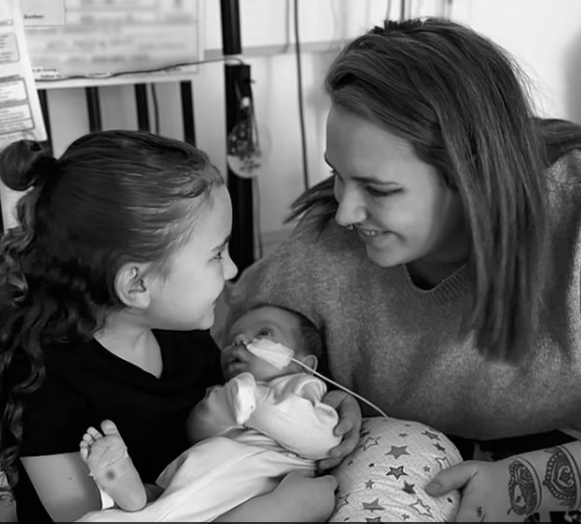  Grace, 25 tuổi (ảnh bên phải) và Rhys James, 26 tuổi, đến từ Bridgend, xứ Wales, đã có một thai kỳ suôn sẻ và chỉ biết về tình trạng của con trai mình sau khi cậu bé chào đời và được đưa đến phòng chăm sóc đặc biệt (ảnh chụp cùng chị gái của Vinnie)