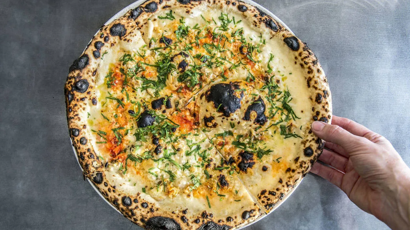 Tiệm Bella Brutta, Sydney, Úc. Pizza nghêu ở đây đã được chọn. Pizza gồm: nghêu, phô mai, ớt, tỏi và rau mùi tây. Đế bánh phồng xốp, có độ dai vừa phải và cháy xém - Ảnh: Cassandra Hannagan