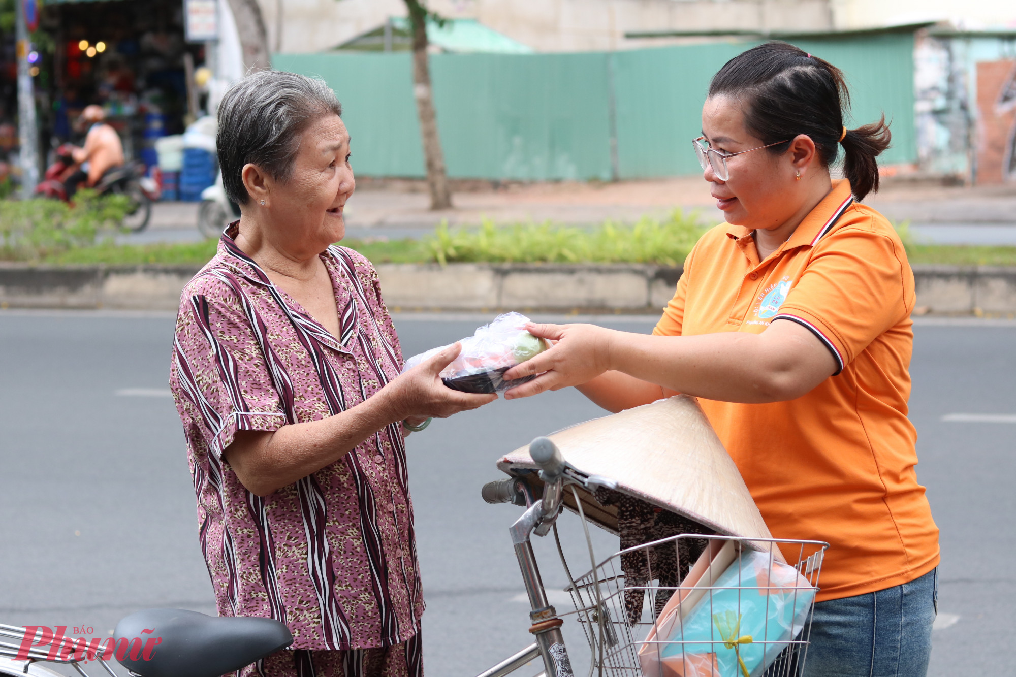 Chị em trao hộp nui xào thịt bò tận tay người cần.  