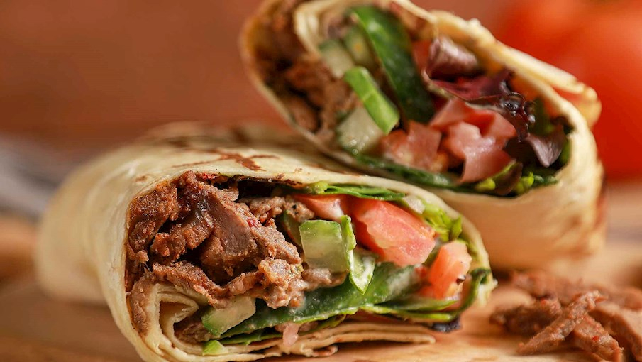 Shawarma là món ăn đường phố phổ biến trong ẩm thực Trung Đông, đặc biệt là ở các quốc gia như Lebanon, Syria, và Thổ Nhĩ Kỳ. Nó thường được chế biến từ thịt cừu, gà, bò hoặc lợn, được ướp gia vị và quay trên lửa hoặc vỉ nướng. Shawarma thường được phục vụ trong bánh mì pita hoặc bánh mì mỏng, kèm theo rau củ, sốt tỏi, hoặc tahini. Món ăn này có vị ngon, đậm đà và rất dễ ăn. 