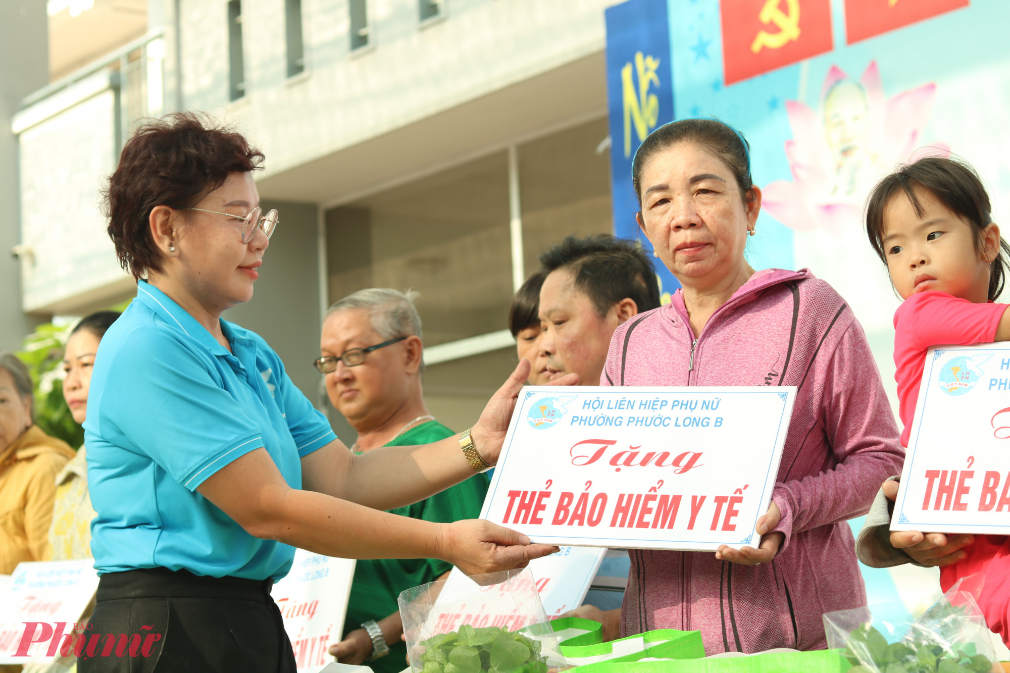 Chị Nguyễn Thị Phương Quyên trao bảng tượng trưng tặng bảo hiểm y tế cho chị em có hoàn cảnh khó khăn trên địa bàn phường vào tháng 9/2024.