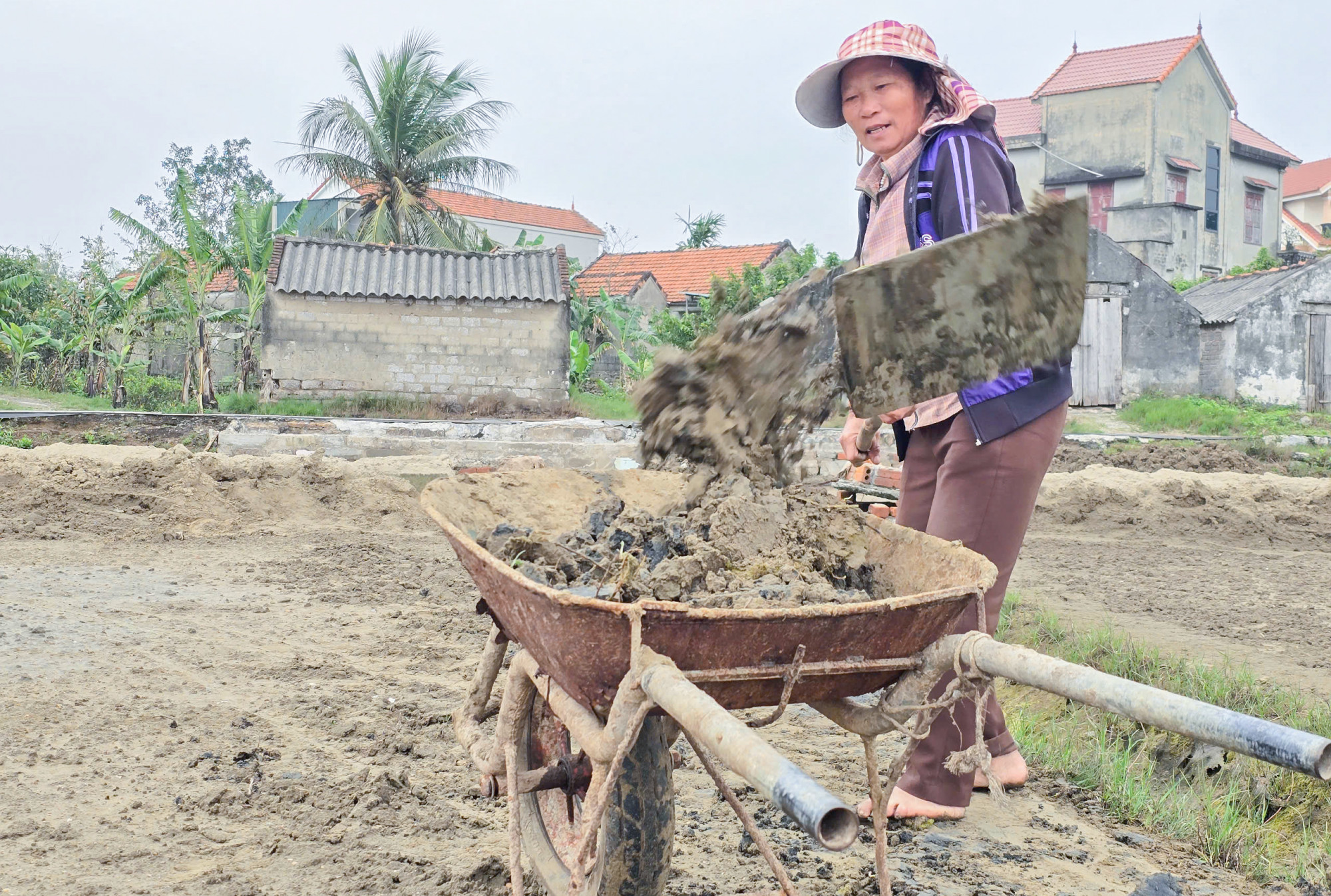 Bà Ngân sửa sang lại các ruộng muối để chuẩn bị vào chính vụ làm muối - Ảnh: Phan Ngọc