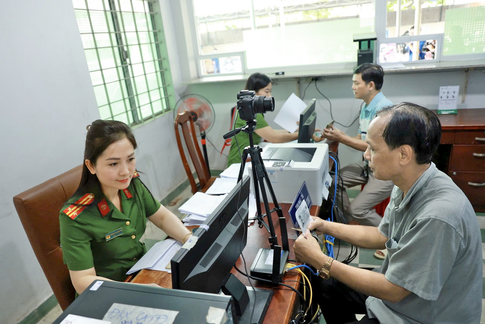 Cán bộ Công an phường Bình Thọ, TP Thủ Đức, TPHCM hướng dẫn, thực hiện thủ tục tiếp nhận hồ sơ cấp đổi giấy phép lái xe cho người dân