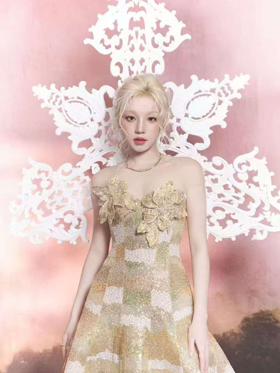Toàn bộ thân váy sử dụng chất liệu organza ánh kim kết hợp sequin nhập khẩu, tạo nên hiệu ứng chuyển sắc lấp lánh như cát vàng chuyển động dưới ánh hoàng hôn. Thiết kế được hoàn thiện hoàn toàn thủ công trong 280 giờ.