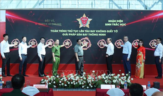 Thủ tướng Phạm Minh Chính và các đại biểu bấm nút triển khai giải pháp ứng dụng định danh, xác thực điện tử, và nhận diện sinh trắc học phục vụ lên tàu bay. Ảnh: Dương Giang - TTXVN