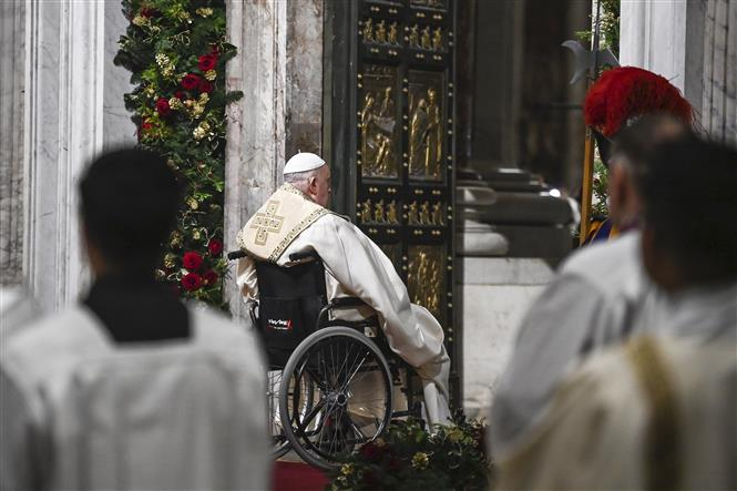 Giáo hoàng Francis ngồi trên xe lăn, mở cánh cửa khổng lồ bằng đồng mang tên Cửa Thánh (Holy Door) tại Vương cung thánh đường Thánh Peter ở Vatican, đánh dấu bắt đầu Năm Thánh 2025. Ảnh: AA/TTXVN