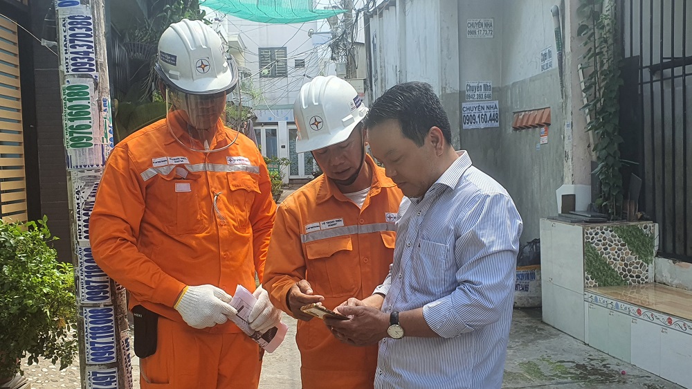 Nhân viên điện lực tuyên truyền việc sử dụng app CSKH - Ảnh: EVNHCMC