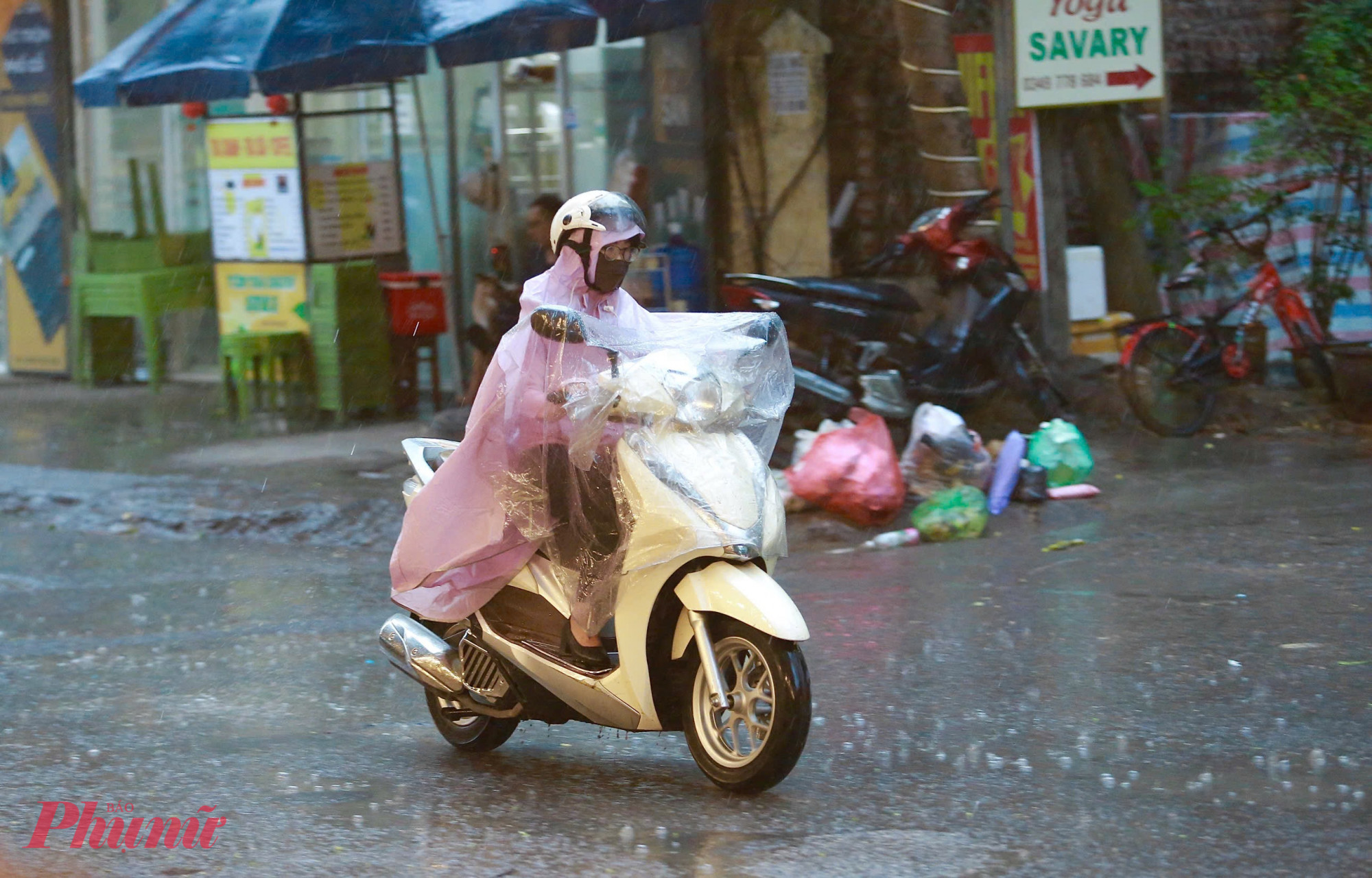 Người đi làm hòa mình trong cơn mưa vàng giải nhiệt.