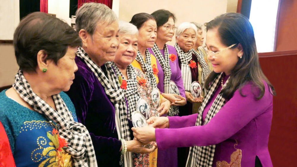 Bà Nguyễn Thị Lệ (bìa phải) - Phó bí thư Thành ủy, Chủ tịch HĐND TPHCM - trao biểu trưng in bức ảnh “Bắc Nam sum họp” cho những nữ chiến sĩ cách mạng từng bị giặc bắt tù đày nhân dịp họp mặt kỷ niệm 50 năm ngày giải phóng miền Nam, thống nhất đất nước - ẢNH: THU LÊ