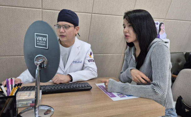 Bác sĩ phẫu thuật trưởng Choi Soon-woo tại Phòng khám phẫu thuật thẩm mỹ View ở Gangnam, phía nam Seoul, đang trò chuyện với bệnh nhân người Mông Cổ Natsagdorj Namuun, ngày 16 tháng 4. Ảnh của Korea Times do Park Ung chụp