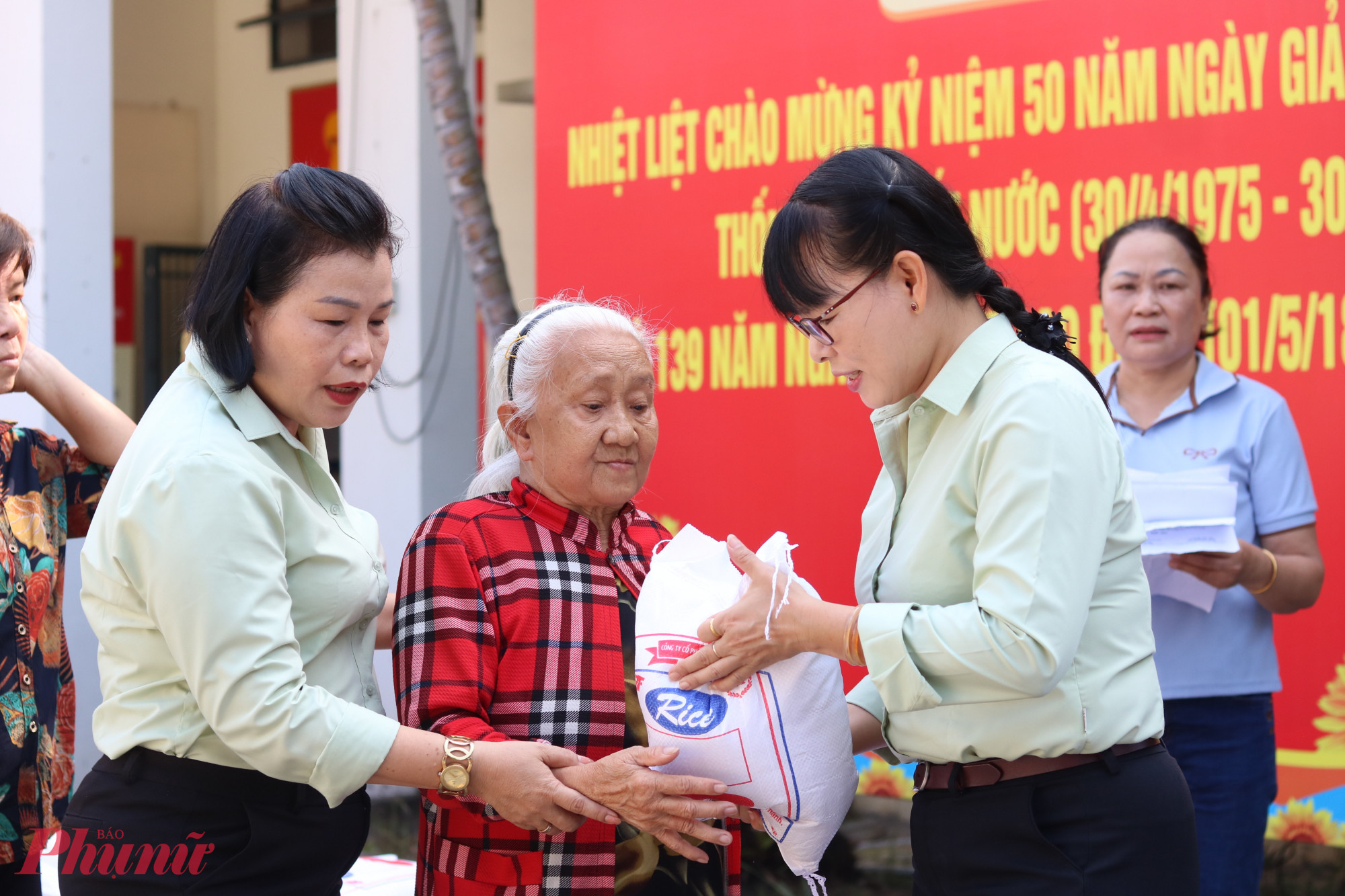 Bà Nguyễn Thị Vân (giữa) phấn khởi trước món quà ý nghĩa được tặng đúng dịp kỷ niệm 50 năm thống nhất non sông. 